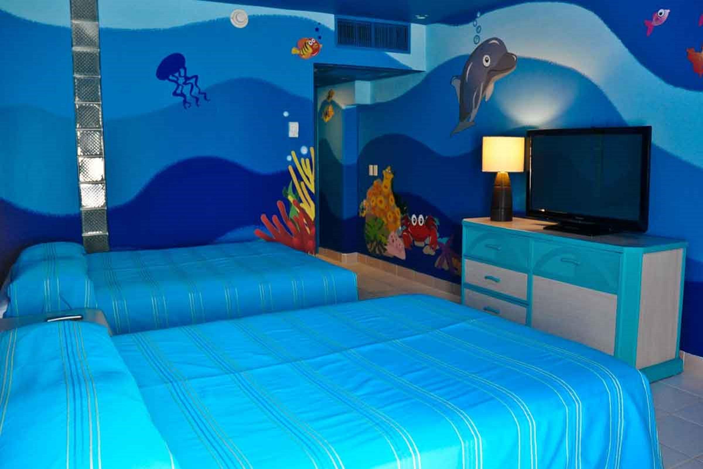 แกรนด์ โอเอซิส ปาล์ม ออล อินคลูซีฟ Hotel แคนคูน ภายนอก รูปภาพ The photo shows a brightly colored hotel room with a themed underwater design. The walls are painted in various shades of blue, resembling ocean water, and feature colorful sea creatures such as fish and a dolphin. There are two beds with blue stripe